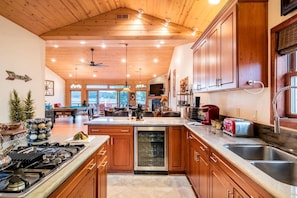 A spacious kitchen with wooden cabinets, a central island, and a built-in dishwasher. - Experience Bliss: Big Bear Lake Rental with Exclusive Hot Tub (Big Bear Lake)