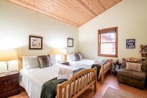 A cabin with two beds, wooden headboards, a wooden ceiling, framed artwork, a window with blinds, and a sign saying 'LOVE THE LAKE'. - Experience Bliss: Big Bear Lake Rental with Exclusive Hot Tub (Big Bear Lake)