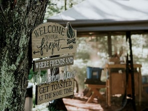 A wooden sign with text welcoming visitors to a retreat, indicating a communal dining area.