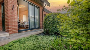 A modern house with a glass door leading to a room with a bed and a table. - Studio at the Vineyards (Iphofen)