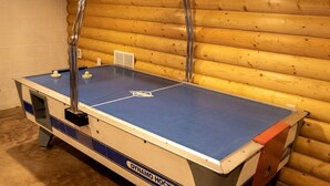 A foosball table in a room with wooden walls and a white brick wall. - Lofted Cabin Wonderful for Outdoor Adventures near Tappan Lake in Ohio (Deersville)