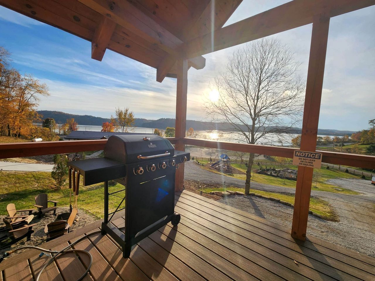 Una griglia da barbecue su un pontile di legno con vista su un lago e montagne.