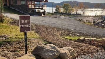 Un edificio de fachada de piedra, un cartel que indica 'BANFF PARKING' y un área de grava en su parte frontal.