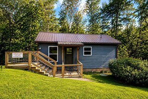 A small, single-story building with a metal roof and a wooden staircase leading to a door. - North Carolina Pet-Friendly Cabin Rental for Romantic Getaways to the Mountains (Spruce Pine)