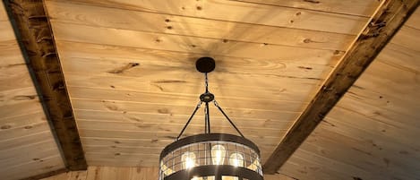 A wooden ceiling with a circular chandelier.