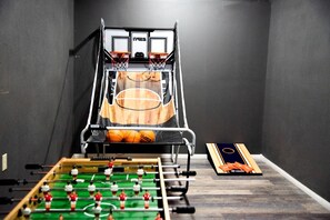 Ein Zimmer mit Basketballkorb, Kicker-Tisch und Futsal-Spielfeld.