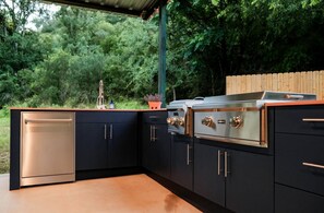 A modern outdoor kitchen with a built-in oven, a sink, and a countertop.