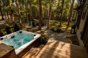 Lämminvesiallas, jonka ympärillä on terassi. Taustalla näkyy metsäinen alue ja ulkokalusteita.