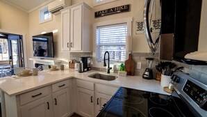 A modern kitchen with white cabinetry, a stainless steel range, and a 'TAKE A HIKE' sign on the wall. - Fantastic Secluded Cabin in Monteagle, Tennessee (Monteagle)