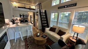 A spacious living area with a sofa, coffee table, and a view of the outside. - Fantastic Secluded Cabin in Monteagle, Tennessee (Monteagle)