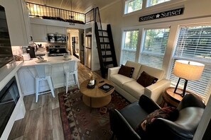 A spacious living area with a sofa, coffee table, and a view of the outside. - Fantastic Secluded Cabin in Monteagle, Tennessee (Monteagle)
