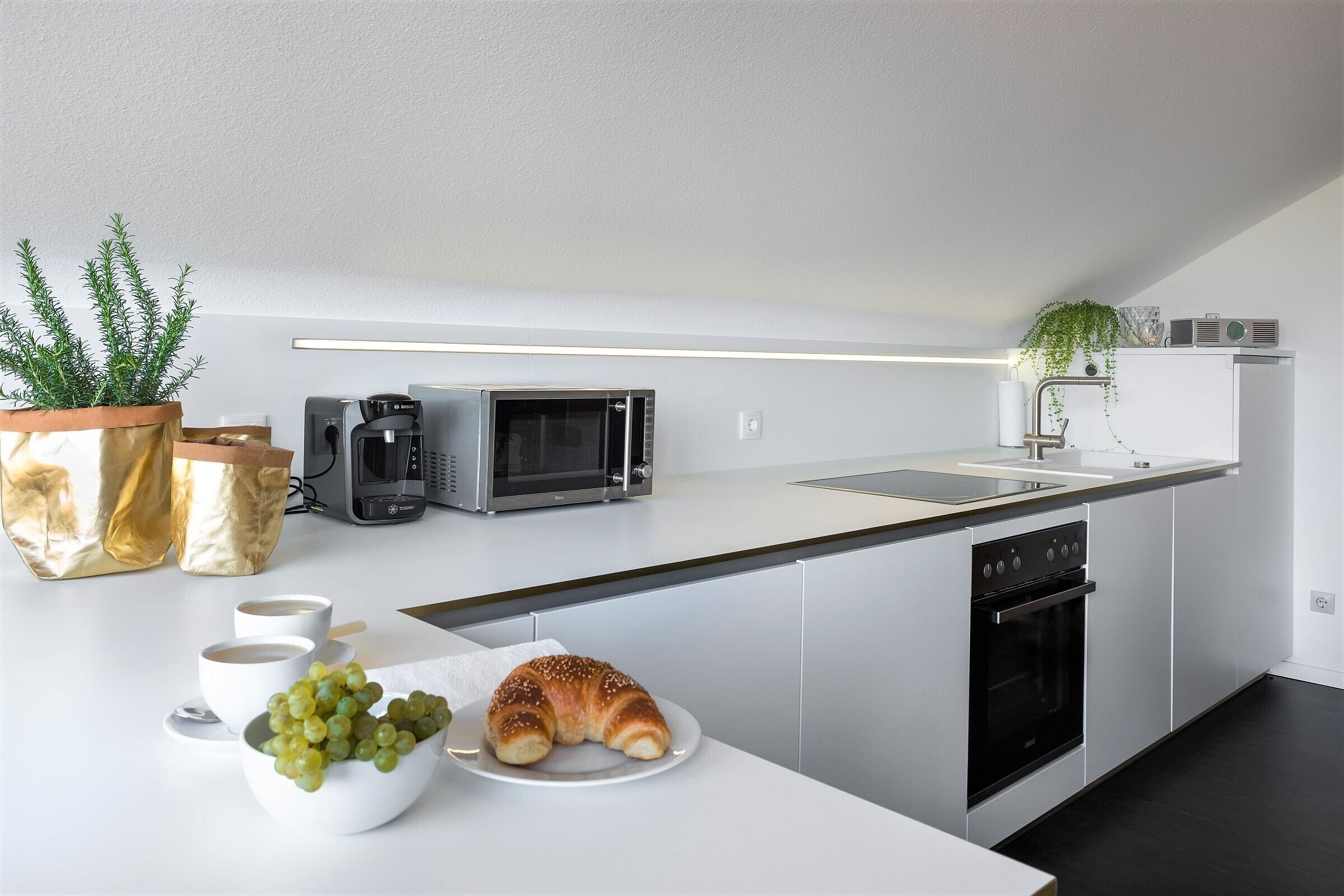 Eine moderne Küche mit Mikrowelle, Backofen und Spüle.