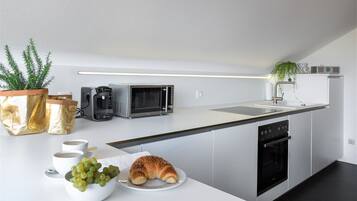 Eine moderne Küche mit Mikrowelle, Backofen und Spüle.