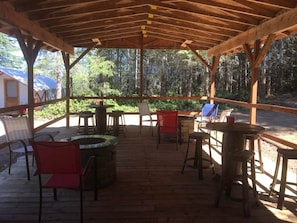 Una terraza de madera al aire libre con asientos y una chimenea.