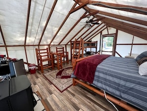 Una habitación con carpa, una cama, un escritorio y una silla.