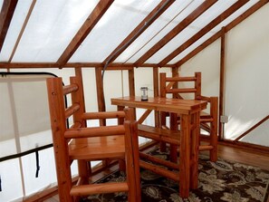 A room with a sloped ceiling, wooden furniture, and a patterned carpet.