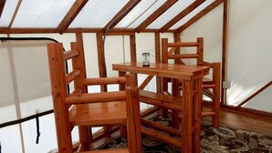 Une pièce avec un plafond en pente, des meubles en bois et un tapis à motifs.