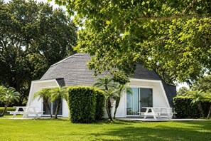 A modern house with a sloped roof, large windows, and a well-maintained lawn.