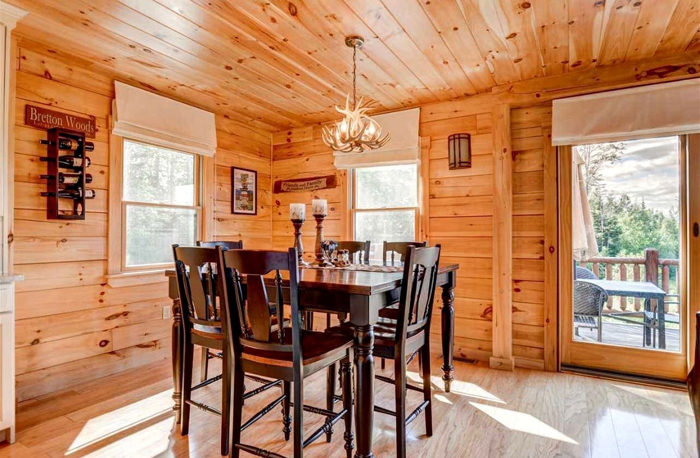 A wooden interior with a dining table, chairs, a chandelier, and a sign reading 'Bretton Woods.'