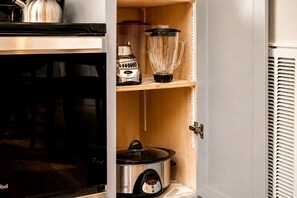 A kitchen with a stove, a blender, a kettle, and a slow cooker. - Exquisite Cabin with Stunning Interior, Outdoor Deck and Hot-Tub in Tennessee (Tracy City)