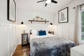 A bedroom with a bed, bedside tables, a ceiling fan, and a window with curtains. - Exquisite Cabin with Stunning Interior, Outdoor Deck and Hot-Tub in Tennessee (Tracy City)