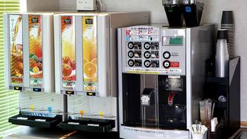 Eine Kaffeemaschine mit mehreren Ausgabespeichern für verschiedene Kaffeesorten und einem Wasserhahn.