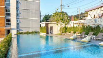 Een buitenzwembad, parasols voor strand/zwembad