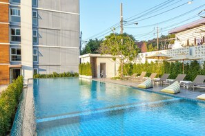 Una piscina al aire libre, sombrillas, tumbonas
