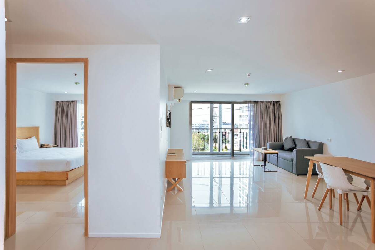 Une chambre d’hôtel moderne équipée d’un lit, d’un bureau, d’un canapé et d’une table à manger.