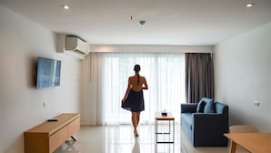 Een moderne woonkamer met een bank, een televisie en een houten tafel.