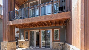 A two-story building with a balcony, large windows, and stone pillars. - Alpenglow - Ski-In/Out Durango Condo with Hot Tub (Durango)