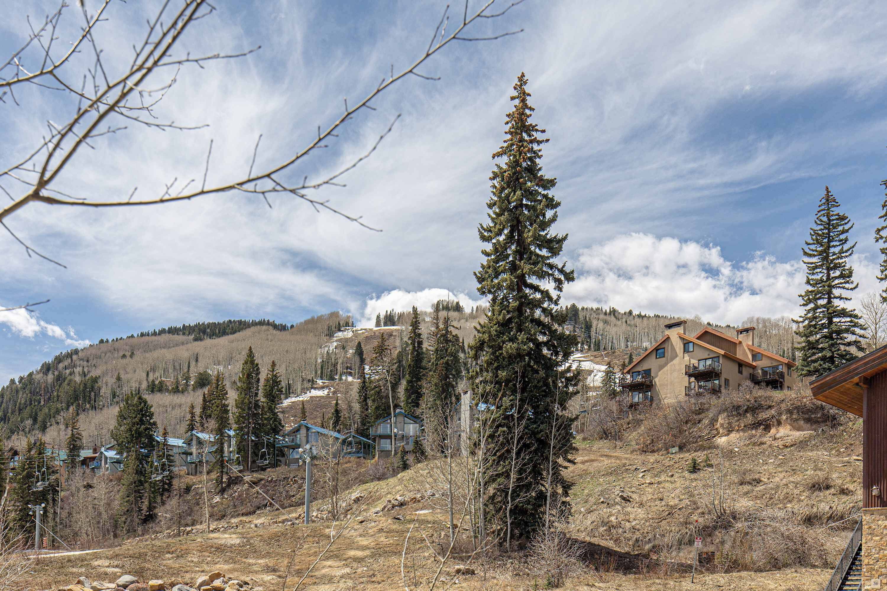 A mountainous area with a ski resort, including buildings and trees.