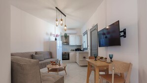 Ein modernes Wohnzimmer mit Sofa, Couchtisch und einem an der Wand befestigten Fernseher.