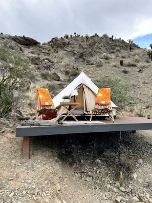 A tent with two chairs and a table on a platform. - Luxurious and Comfy Bell Tent in the Stunning Nevada Desert (Boulder City)