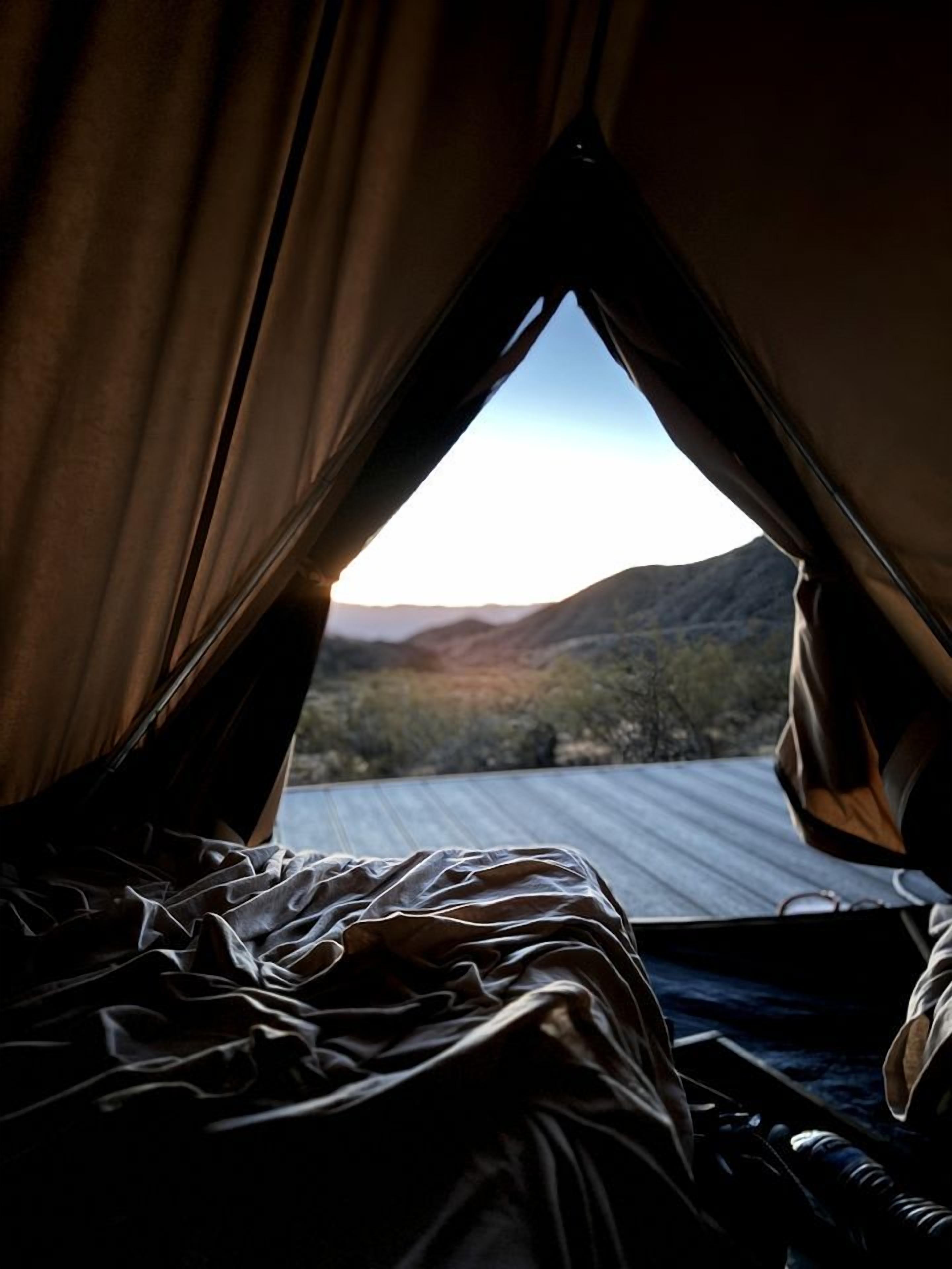 A tent with a view of a mountainous landscape.