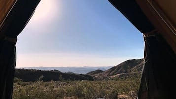 A tent with a view of a mountainous landscape.