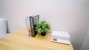 A wooden table with a book titled 'Tom Ford', a small potted plant, and a white box. - Swing & Pillows at Penang Road (George Town)