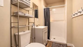 Une salle de bain équipée de toilettes, d’un lavabo, d’une douche et d’un porte-serviettes.