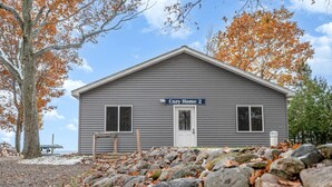 A two-story building with a gray exterior, a front door, and a sign that reads 'Cozy Home 2'.