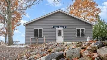 A two-story building with a gray exterior, a front door, and a sign that reads 'Cozy Home 2'.