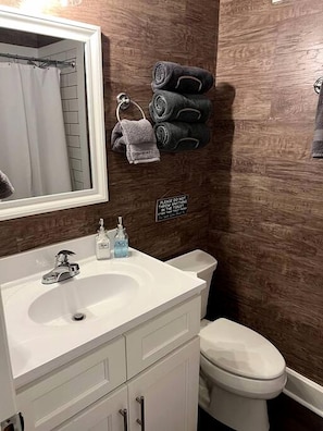 A bathroom with a white sink, a mirror, a toilet, and a sign on the wall. - Riverfront Cottage with Barbecue, Kayaks and Dock in Charlotte, North Carolina (Charlotte)