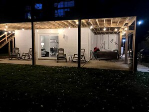 A covered outdoor area with seating and a staircase leading to an interior space.