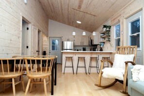 A wooden interior with a dining area, kitchen, and seating.