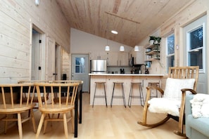 Un interior de madera con comedor, cocina y zona de estar.