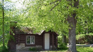 A rustic log cabin with a stone foundation, a wooden door, and a window. - Rustic Log Cabin for a Relaxing Escape in Markleysburg, Pennsylvania (Markleysburg)