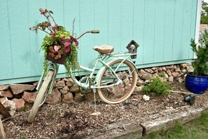 A vintage bicycle with a basket and a seat, parked against a teal wall. - Sweet Tiny House Perfect for a Romantic Retreat in Alabama (Rogersville)