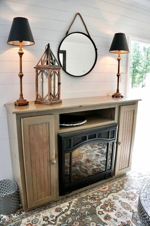 A wooden cabinet with a mirror, two lamps, and a patterned rug. - Sweet Tiny House Perfect for a Romantic Retreat in Alabama (Rogersville)