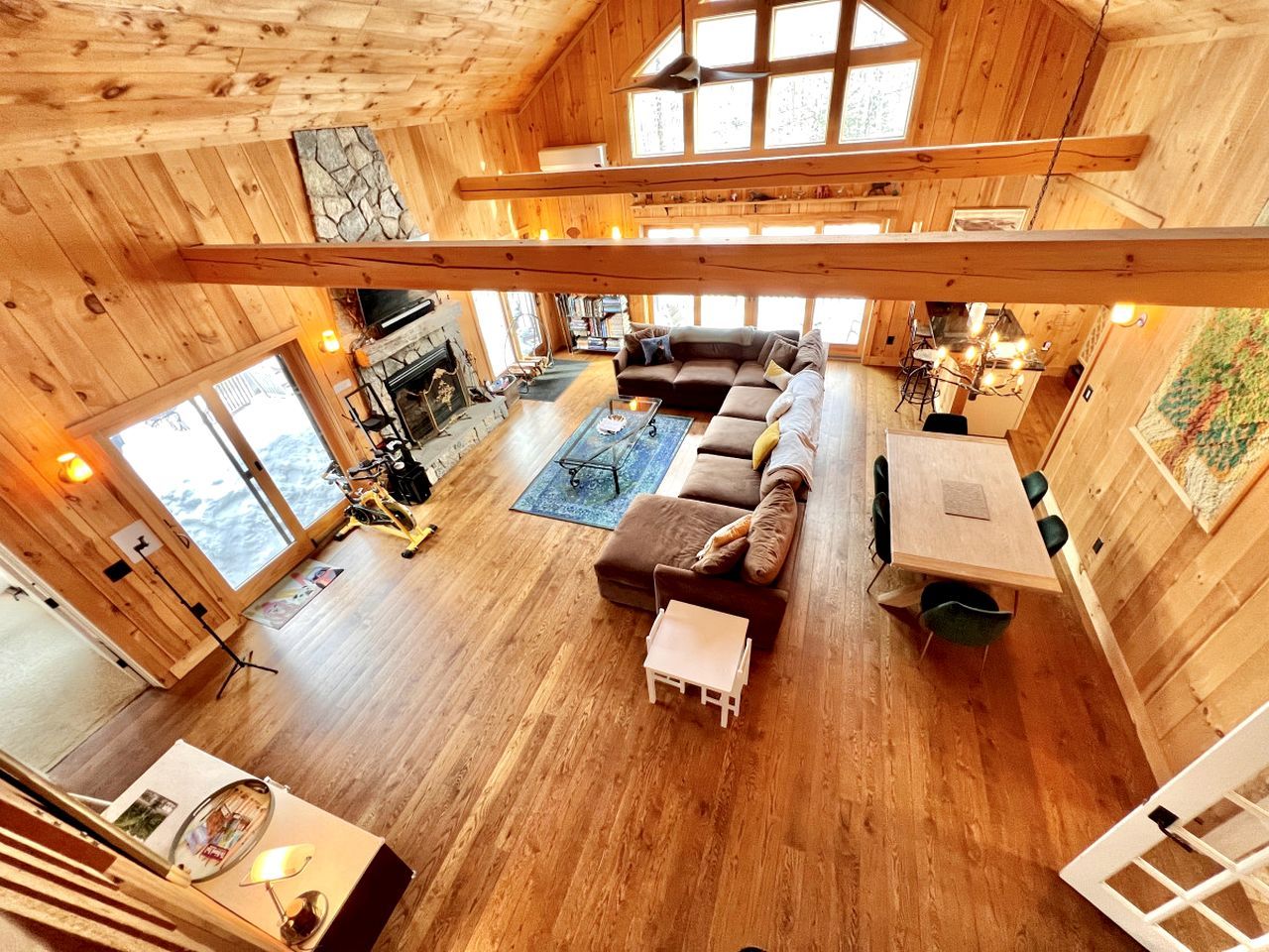 A spacious wooden cabin with a large living area, a fireplace, and a dining table.