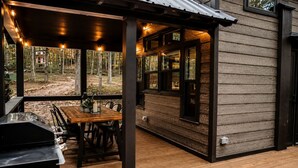 A covered outdoor dining area with a grill, wooden table, and chairs. - Incredible Secluded Cabin wit Barbecue and Privileged Sights in Tracy City, Tennessee (Tracy City)