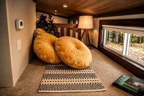 A cozy room with a large window, a lamp, and a rug.